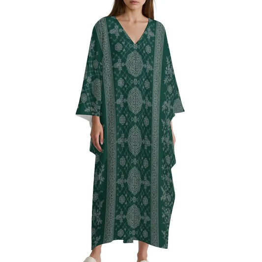 Woman wearing green V-neck kaftan dress with intricate gray floral and geometric patterns