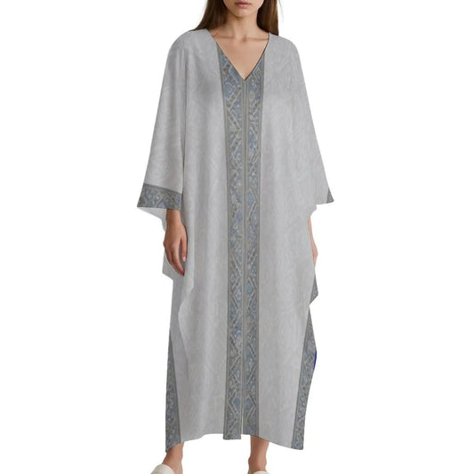 Woman wearing a light gray v-neck kaftan dress with blue and gray geometric border patterns