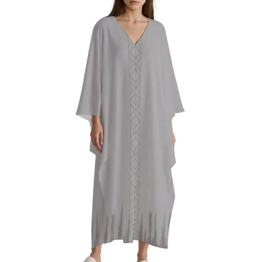 Woman wearing light gray v-neck kaftan dress with long sleeves and geometric center pattern
