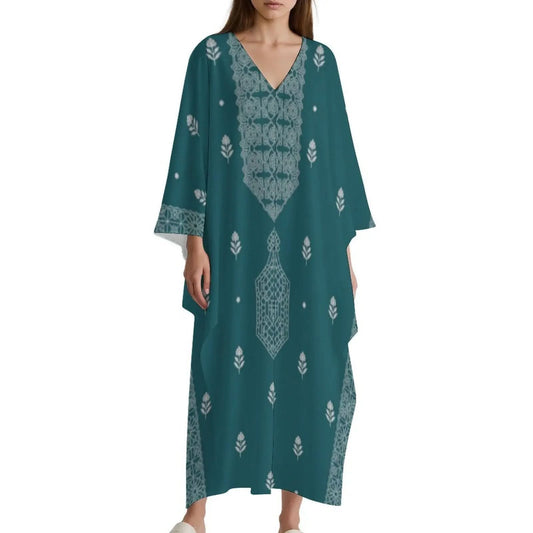 Woman wearing teal V-neck kaftan dress with white intricate floral and geometric patterns