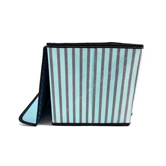 Foldable fabric storage cube with blue and gray vertical stripes and black trim on white background