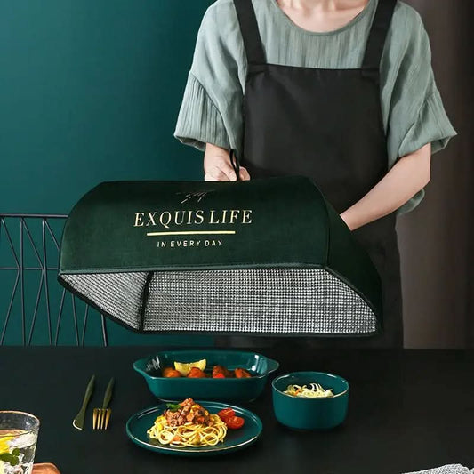 Person lifting dark green food cover labeled Exquis Life over table with pasta and side dishes