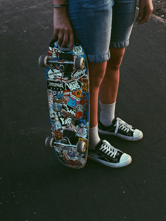 person in blue denim shorts and black and white nike sneakers riding skateboard