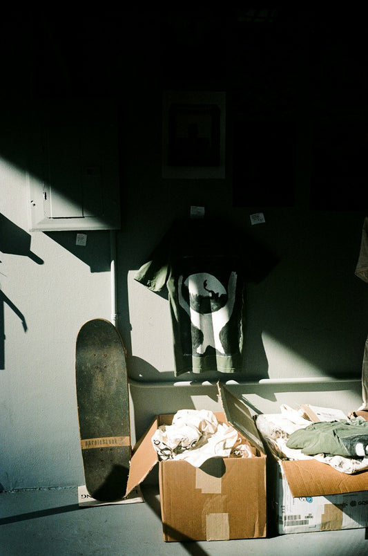 A man standing in front of a skateboard in a room