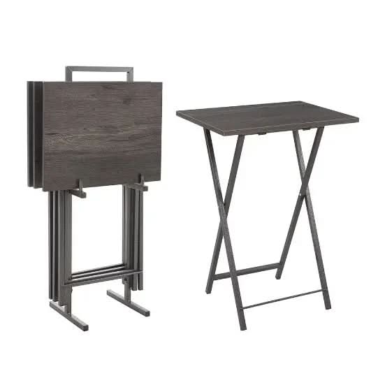 Black foldable TV tray table set with one table folded and four stacked on a white background