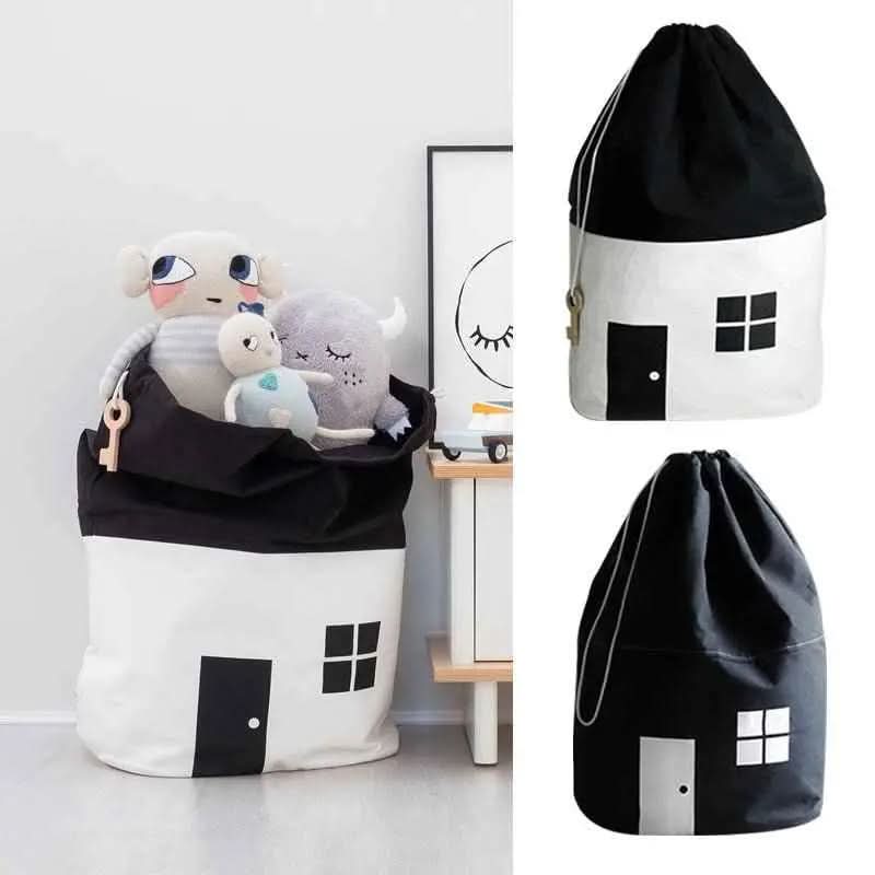 Black and white cotton canvas toy storage bags shaped like houses filled with plush toys in a child room setting