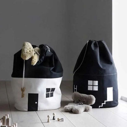 Black and white cotton canvas toy storage bags shaped like houses with drawstring tops in a children's room
