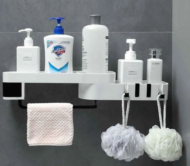 white bathroom corner shelf holding lotion bottles, soap dispenser, pink washcloth, and two hanging bath sponges