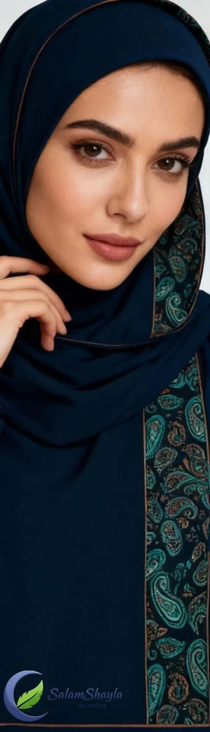 Close-up of woman wearing blue bohemian paisley patterned hijab with makeup, hand near face