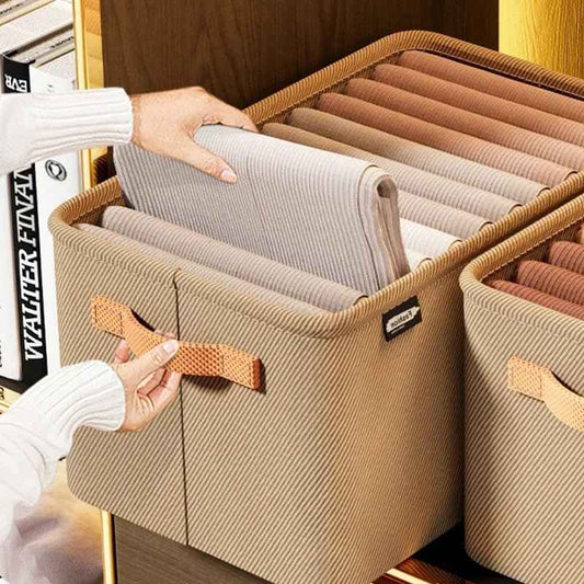 Thick fabric clothes storage box with handles holding neatly folded pants in a home closet