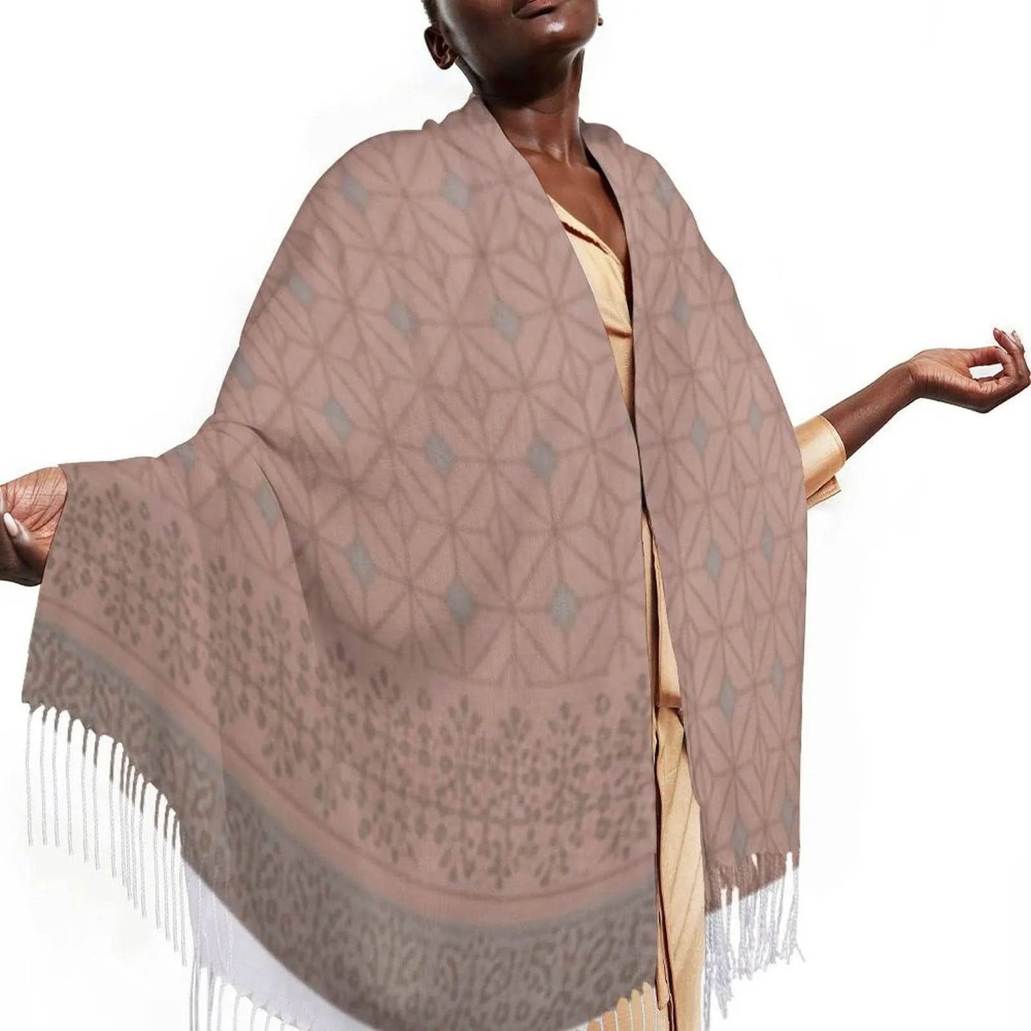 Woman wearing a beige and gray patterned tasseled scarf with geometric and floral designs