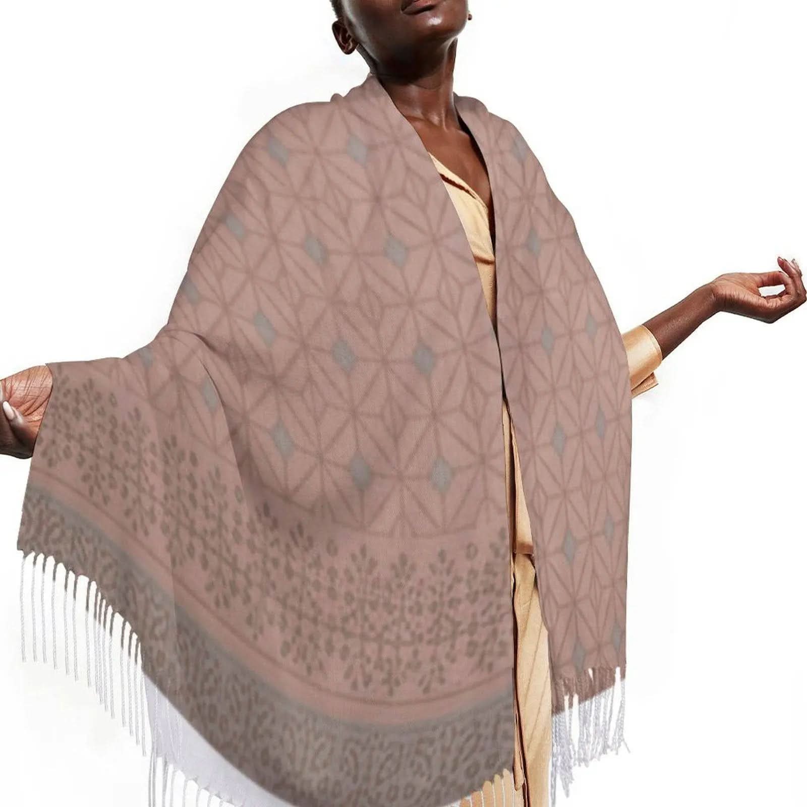Woman wearing a beige and gray patterned tasseled scarf with geometric and floral designs