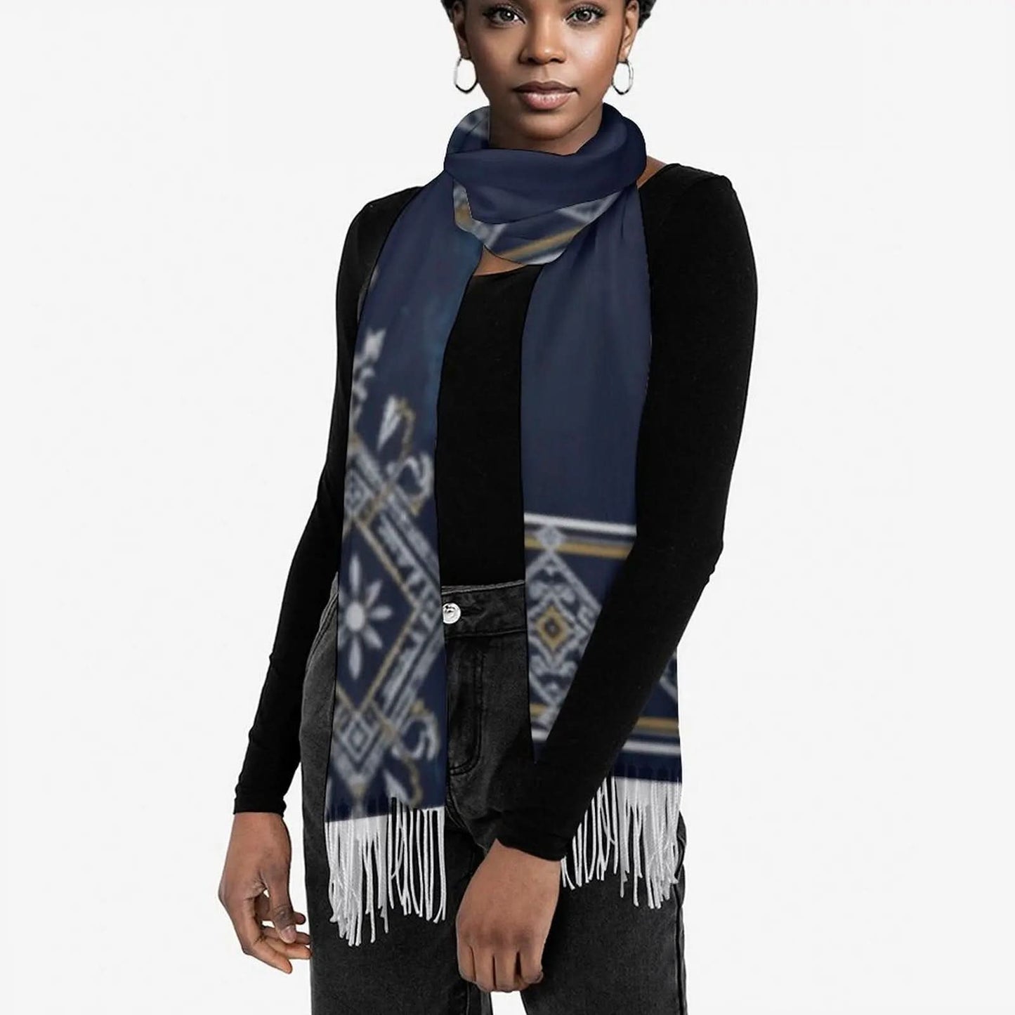 Woman wearing a navy blue tassel scarf with white and gold geometric patterns over a black long-sleeve top