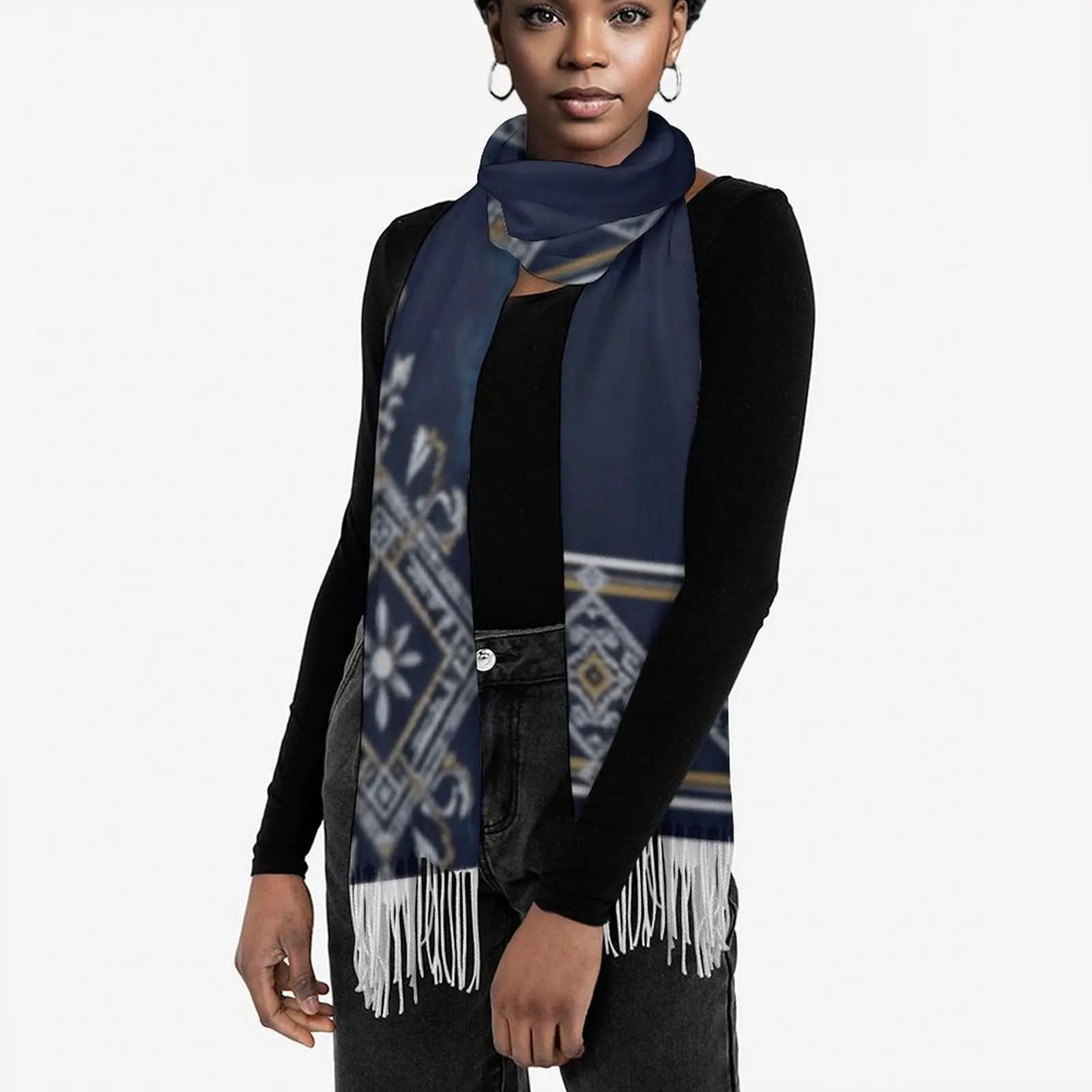 Woman wearing a navy blue tassel scarf with white and gold geometric patterns over a black long-sleeve top