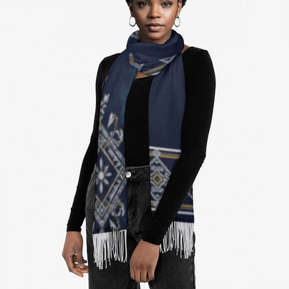 Woman wearing a navy blue tassel scarf with white and gold geometric patterns over a black long-sleeve top
