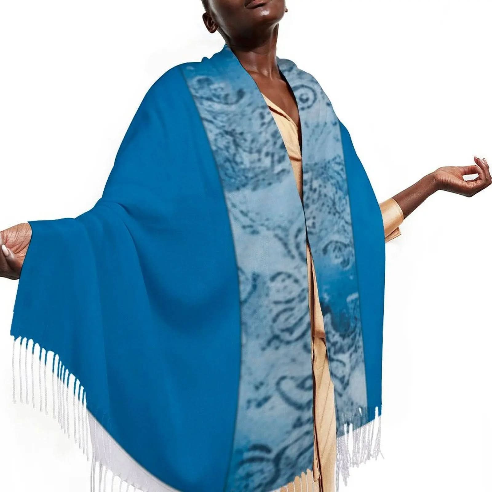 Blue tassel scarf with patterned inner border worn by model in beige outfit on white background