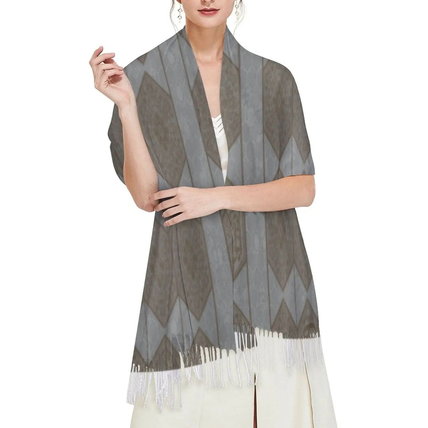 Woman wearing a gray patterned tassel scarf over a white dress, featuring diamond designs