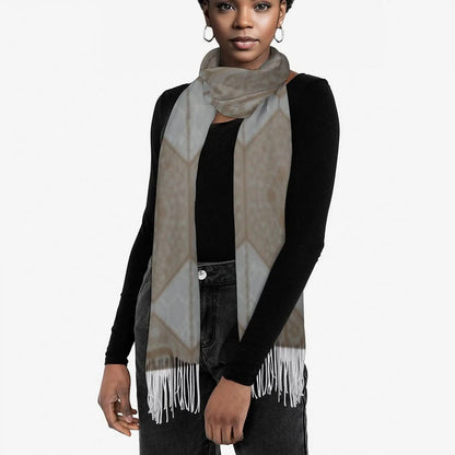 Woman wearing a patterned gray and brown tassel scarf with a black long-sleeve top and dark jeans
