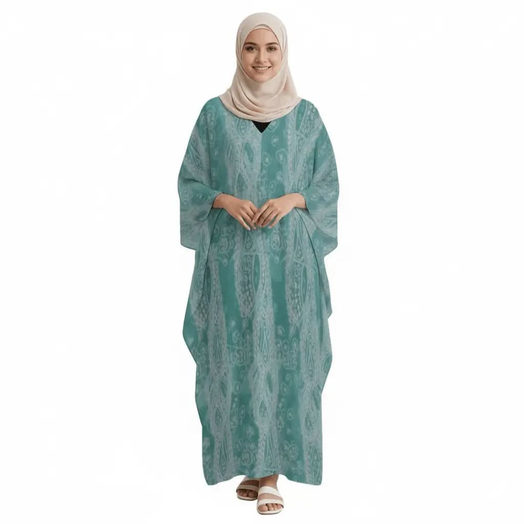 Woman wearing teal printed v-neck kaftan dress with beige hijab and white sandals on white background