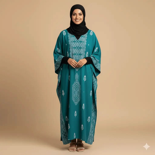 Smiling woman wearing teal V-neck kaftan dress with white floral patterns and a black hijab on beige background