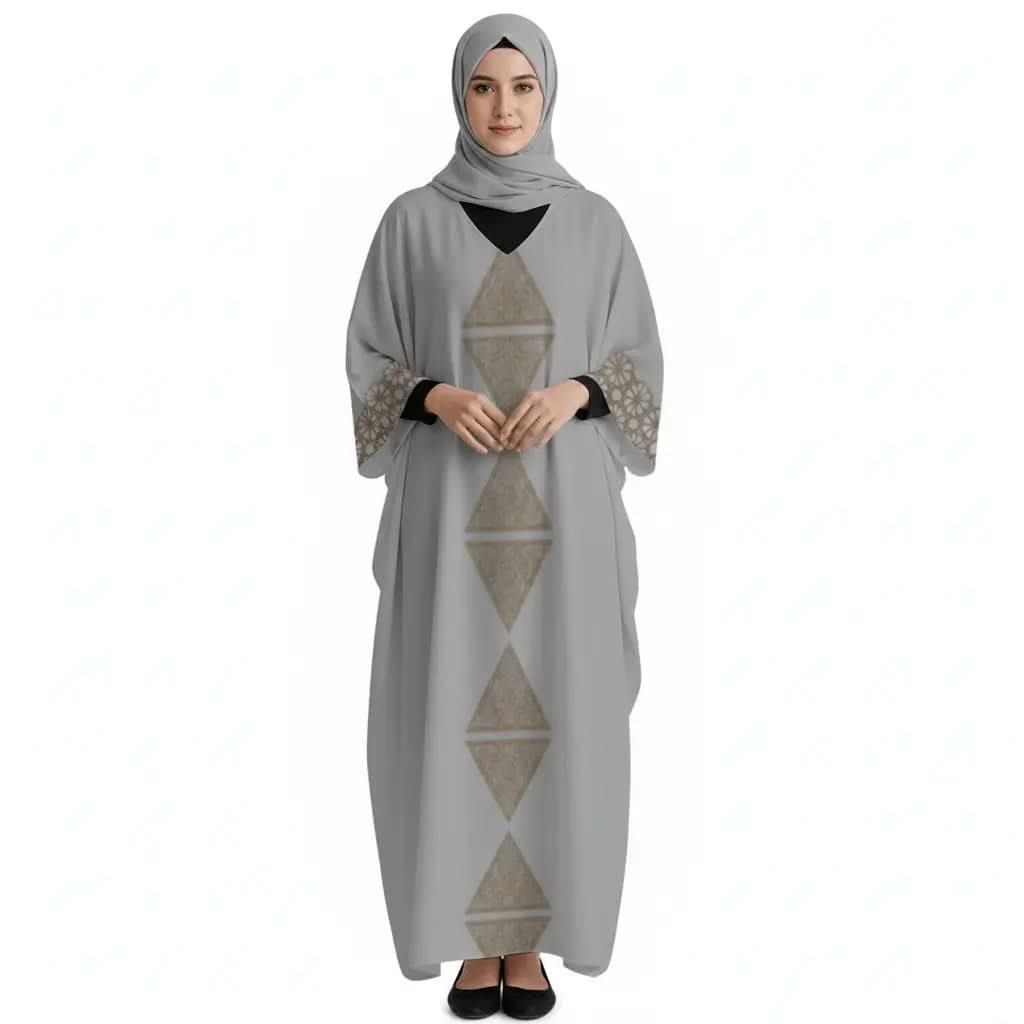 Woman wearing grey V-neck kaftan dress with geometric gold patterns and matching hijab