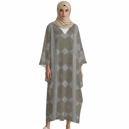 Model wearing grey V-neck kaftan dress with geometric patterns and beige hijab on white background