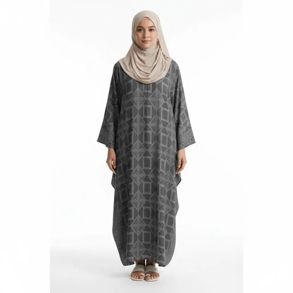 Woman wearing dark grey geometric patterned kaftan dress with beige hijab and white sandals