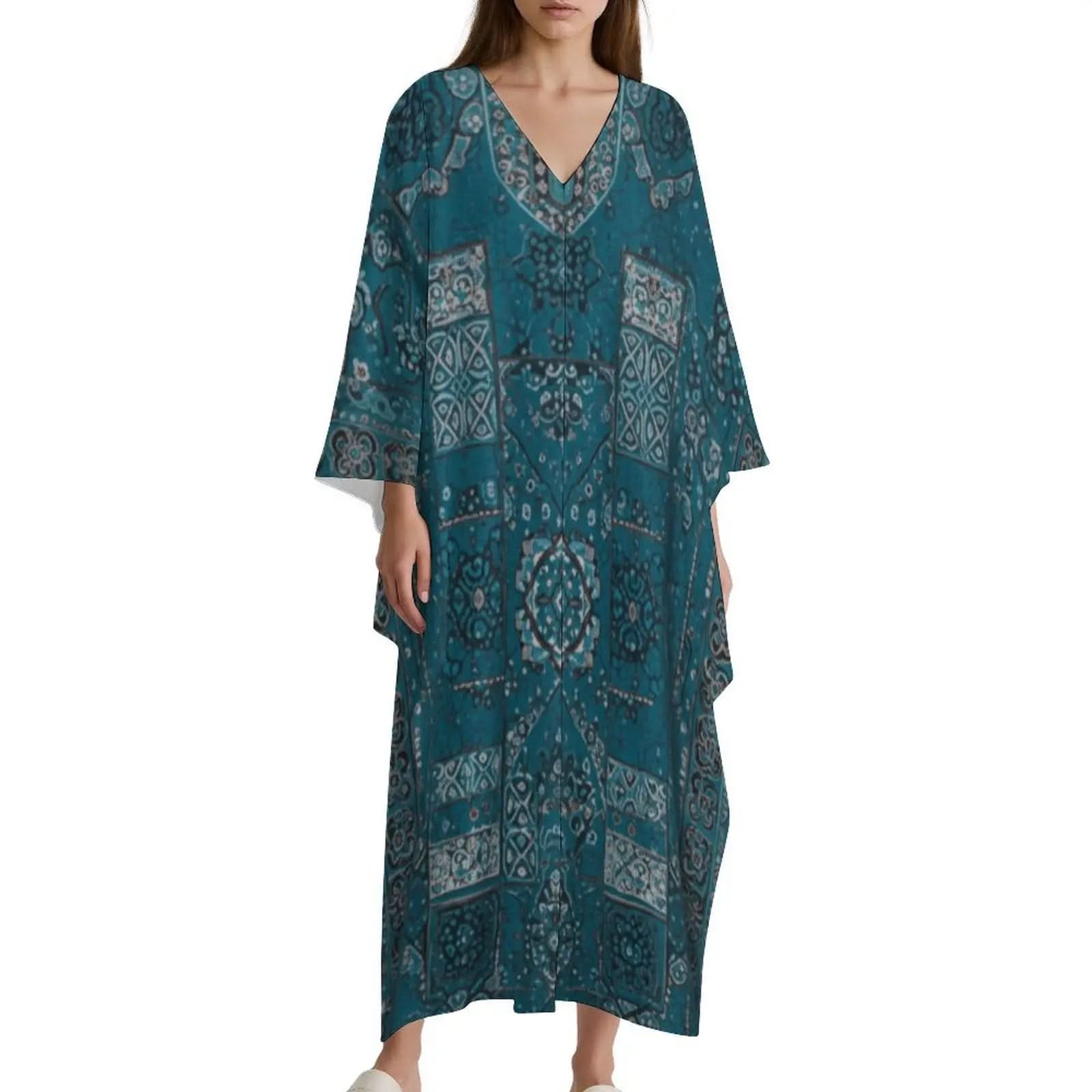 Woman wearing blue V-neck kaftan dress with intricate white and gray patterns on white background