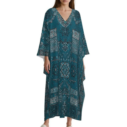 Woman wearing blue V-neck kaftan dress with intricate white and gray patterns on white background