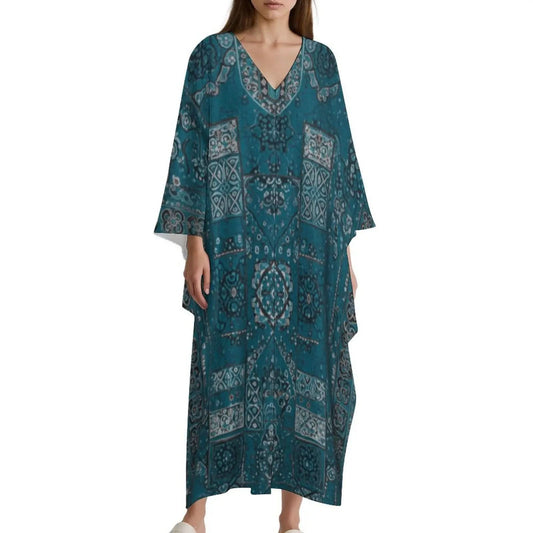Woman wearing blue V-neck kaftan dress with intricate white and gray patterns on white background