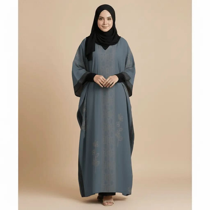 Woman wearing blue v-neck kaftan dress with floral patterns and black hijab on beige background
