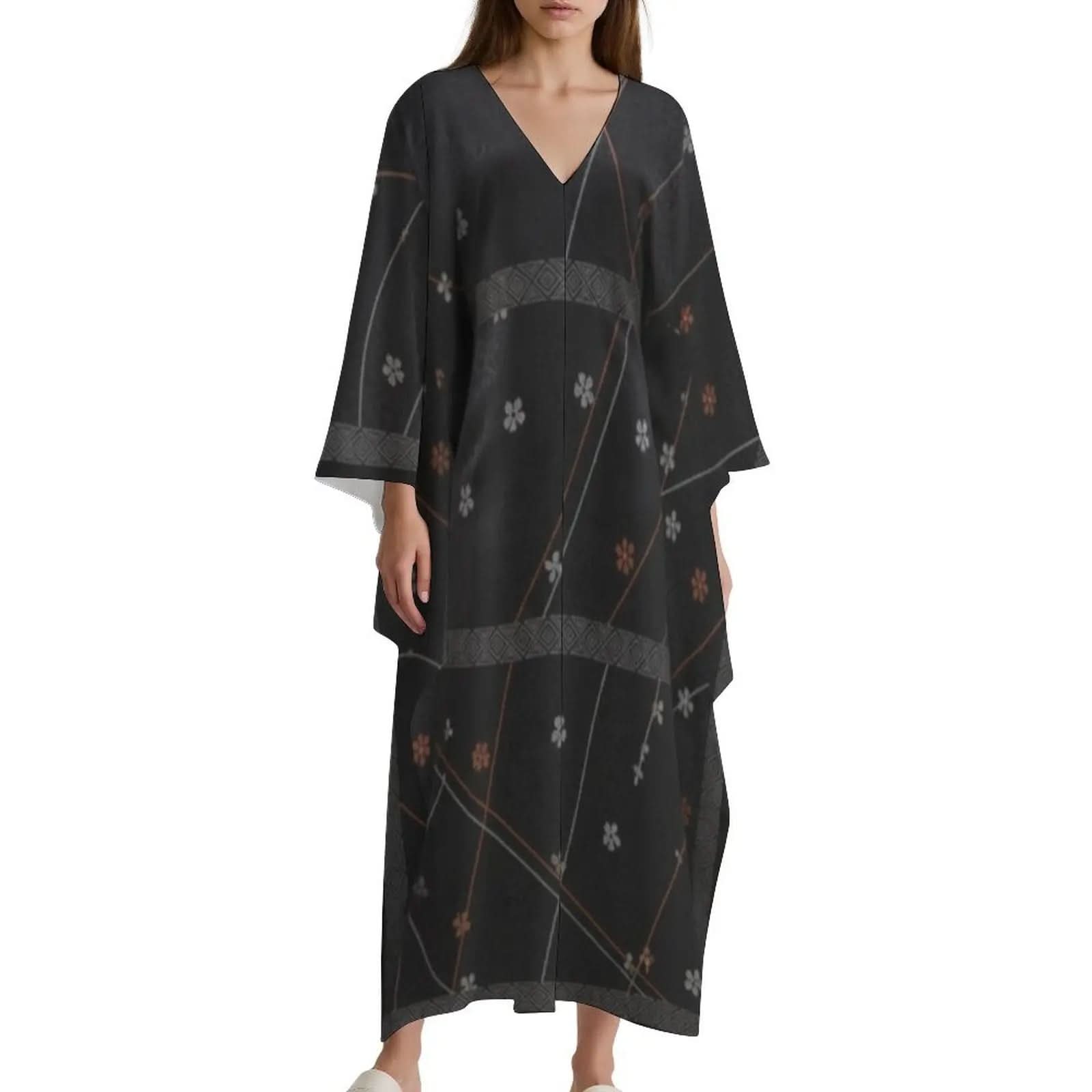 Woman wearing black V-neck kaftan dress with floral and geometric patterns