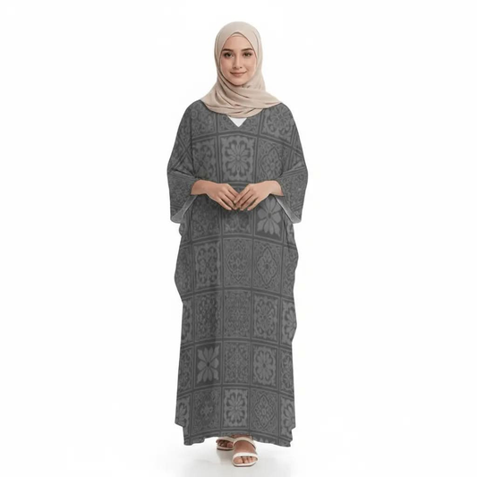 Woman wearing gray patterned V-neck kaftan dress and beige hijab with white sandals on white background