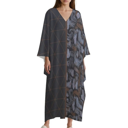 Woman wearing a long V-neck kaftan dress with geometric and abstract patterns in dark tones