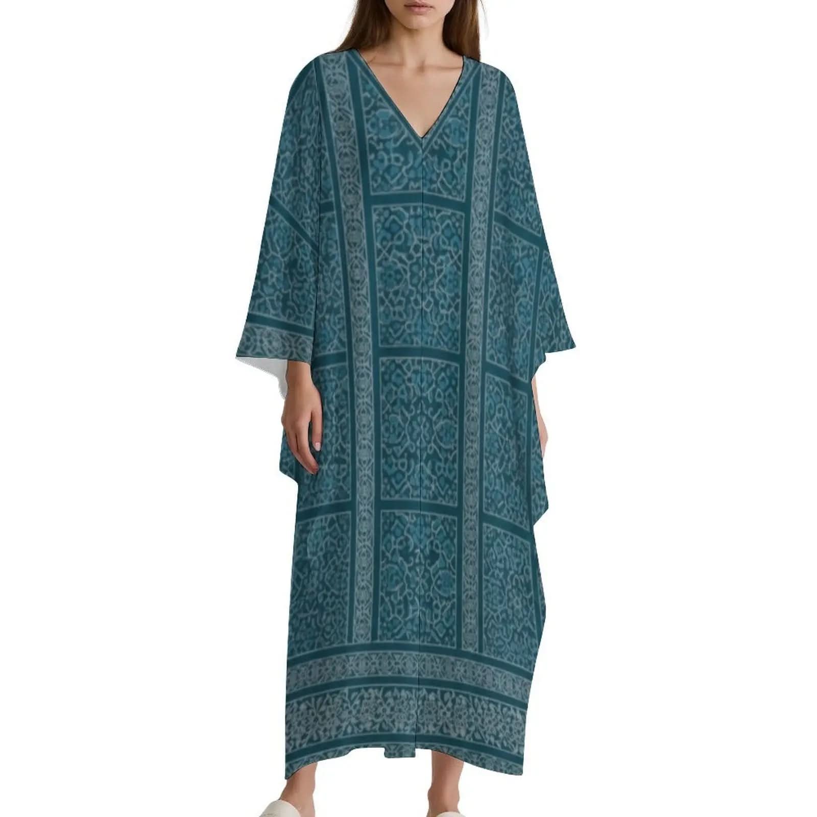 Woman wearing teal blue V-neck kaftan dress with geometric and floral patterns, flowing loose fit