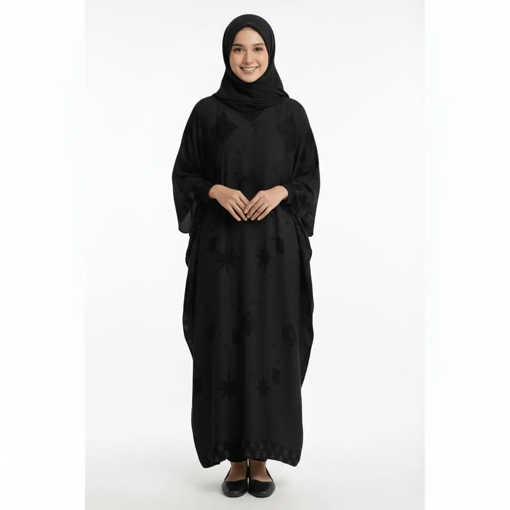 Smiling woman wearing a black V-neck kaftan dress with subtle star and diamond patterns, paired with black hijab and flats