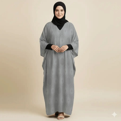 Woman wearing a grey V-neck kaftan dress with subtle geometric pattern and black hijab on beige background