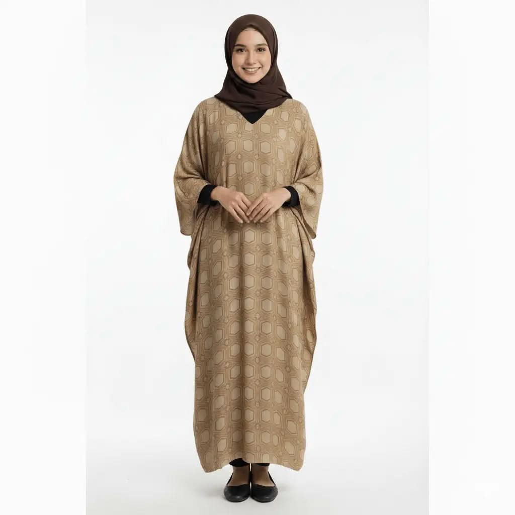 Woman wearing a beige geometric patterned V-neck kaftan dress and brown hijab, standing on white background